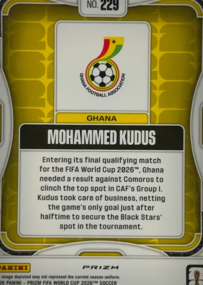 Back of 2026 Panini Prizm FIFA World Cup Soccer Mohammed Kudus #229 Prizm, upright portrait-oriented card back. A gold/yellow patterned field is enclosed by white and gray rounded border elements. Near the top is a white…