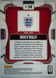 Back of 2026 Panini Prizm FIFA World Cup Soccer Nico O’Reilly #118 Base, upright portrait-oriented card back. A large red central field is framed by a white rounded rectangular border and black textured geometric accents…