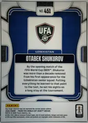 Back of 2026 Panini Prizm FIFA World Cup Soccer OTABEK SHUKUROV #451, back of a portrait-oriented soccer card. A centered top label reads "NO. 451". The upper central panel displays the Uzbekistan Football Association…