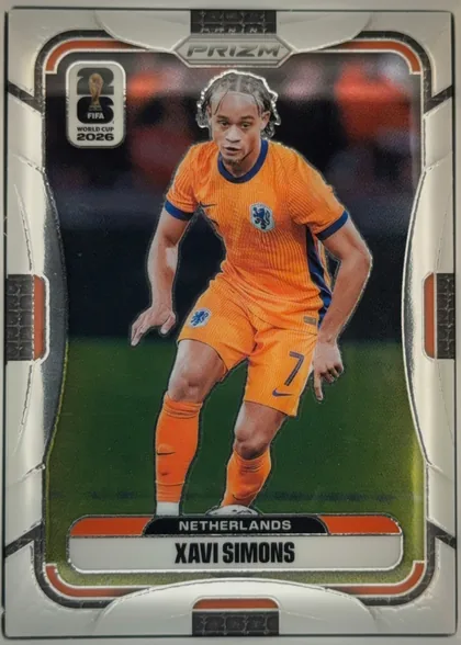 Front of 2026 Panini Prizm FIFA World Cup Soccer XAVI SIMONS #313 Base, portrait-oriented soccer card front. A full-body action image of Xavi Simons in an orange Netherlands kit occupies the center. The FIFA World Cup…