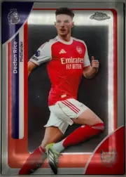Front of 2026 Topps Chrome Premier League Declan Rice #14, front-facing portrait soccer card. A full-body action photograph shows Declan Rice in an Arsenal red-and-white kit against a dark background. His…