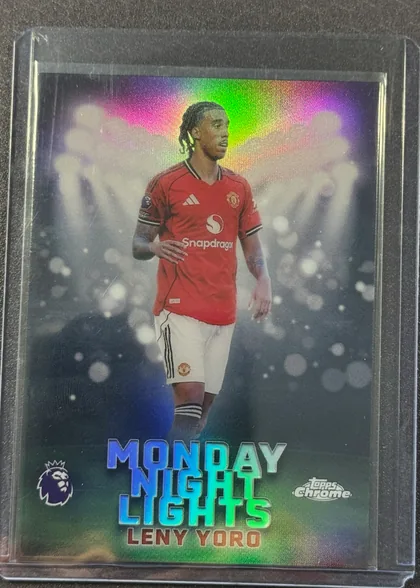 Front of 2026 Topps Chrome Premier League Leny Yoro #MNL-29 Base Insert, portrait soccer card front showing Leny Yoro in a red Manchester United kit against a dark stadium-like background with bright circular light…