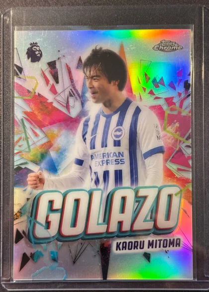 Front of 2026 Topps Chrome Premier League Soccer Cards Kaoru Mitoma #GZ-2 Rainbow foil, upright portrait soccer card front. A player in a blue-and-white striped Brighton shirt is centered against a colorful geometric background with…